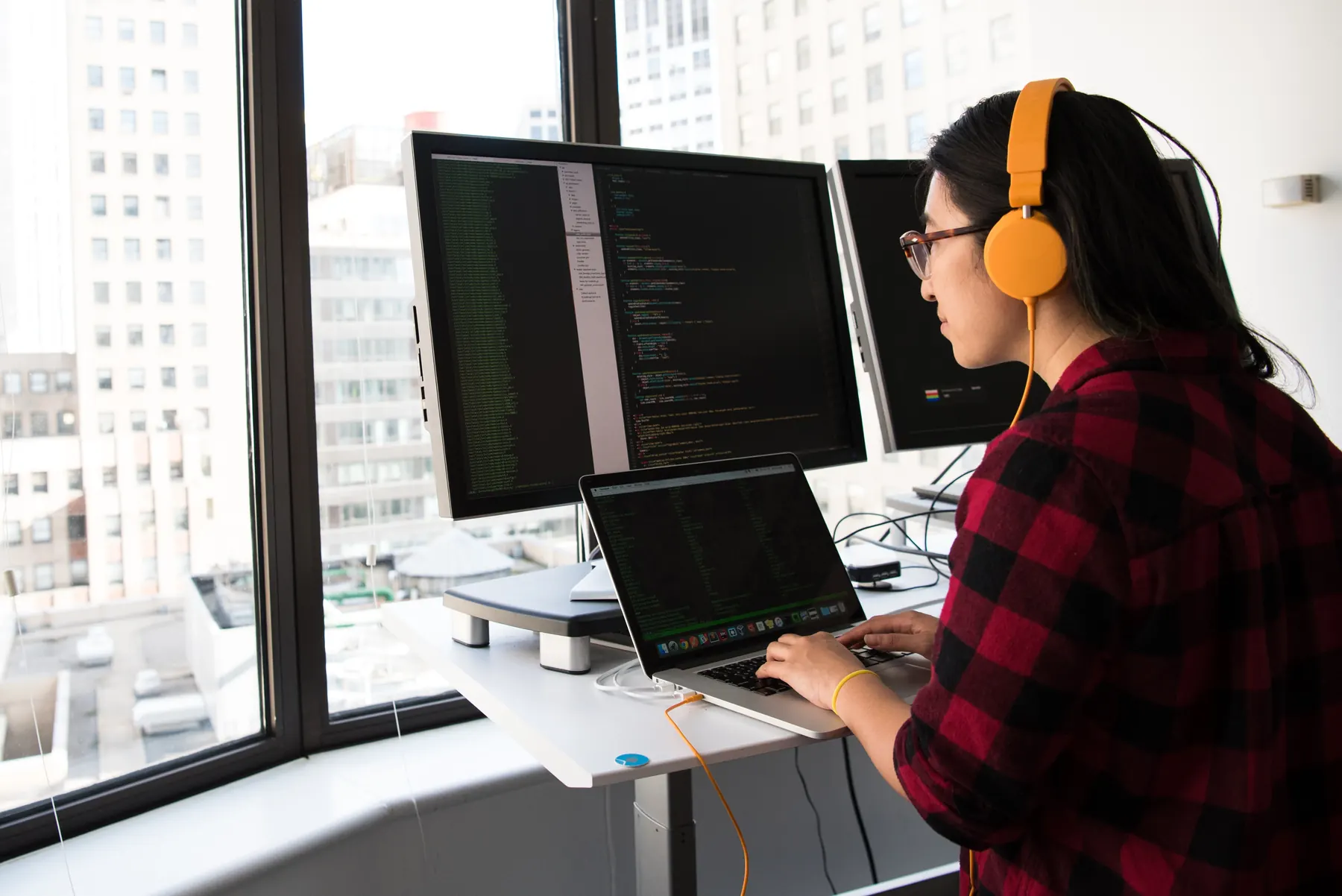 Desarrolladora trabajando con código en un computador portátil
